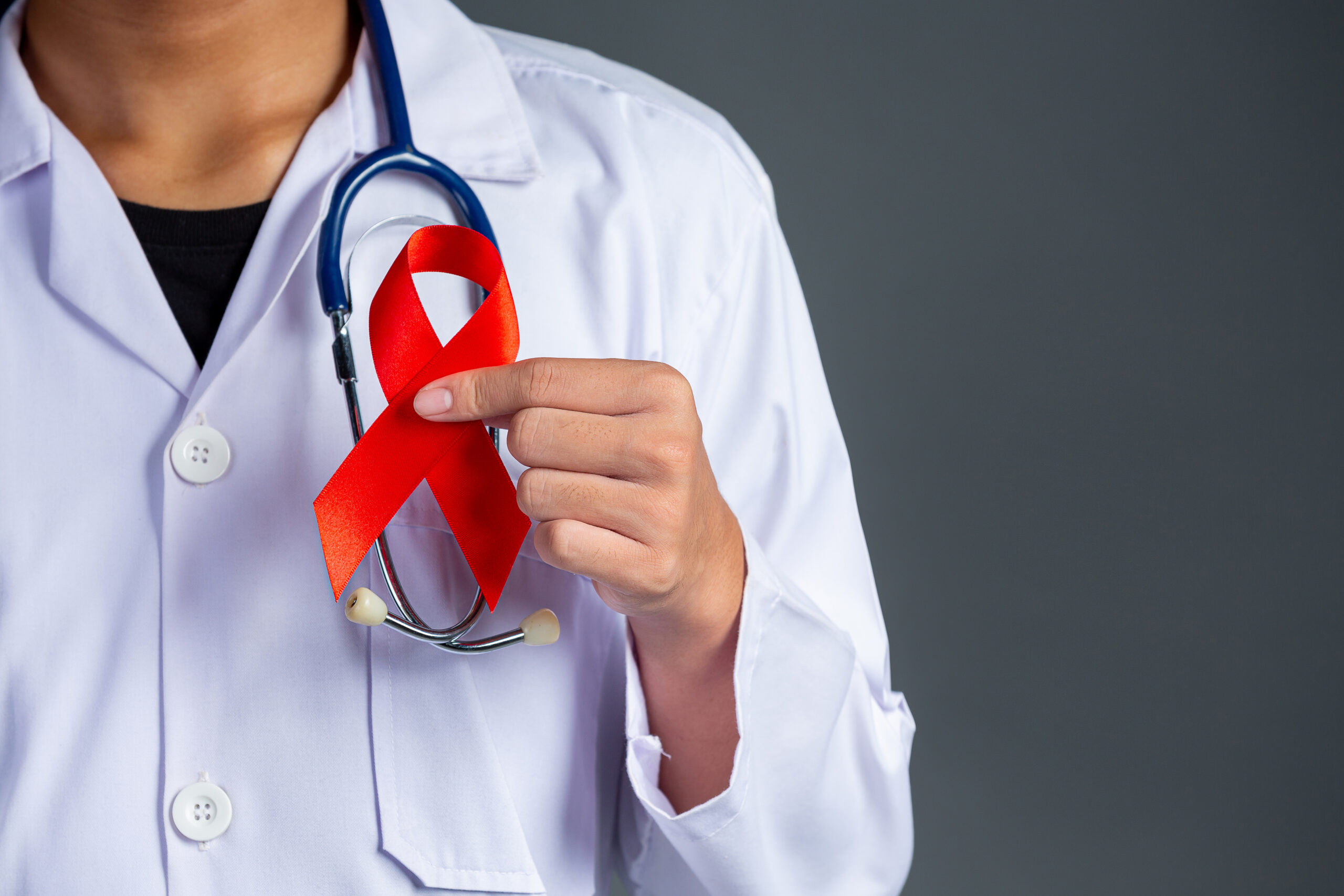 Doctor with red ribbon for HIV Awareness.